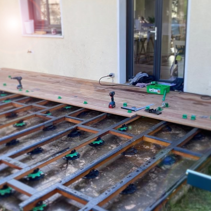 Construction_terrasse_bois_01 Construction d’une terrasse en bois sur plots dans le Val d’Oise, avec installation de lames et ossature en cours.